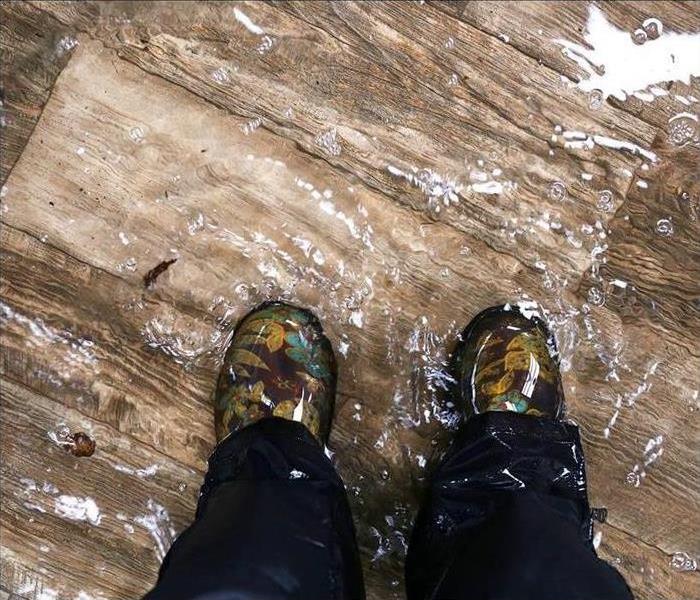 Rubber boots in a pool of water inside a home