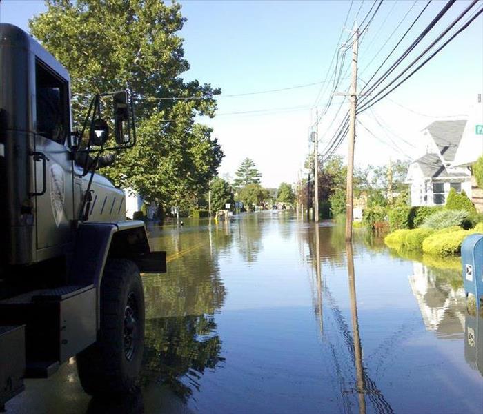 A truck drives down a flooded street.