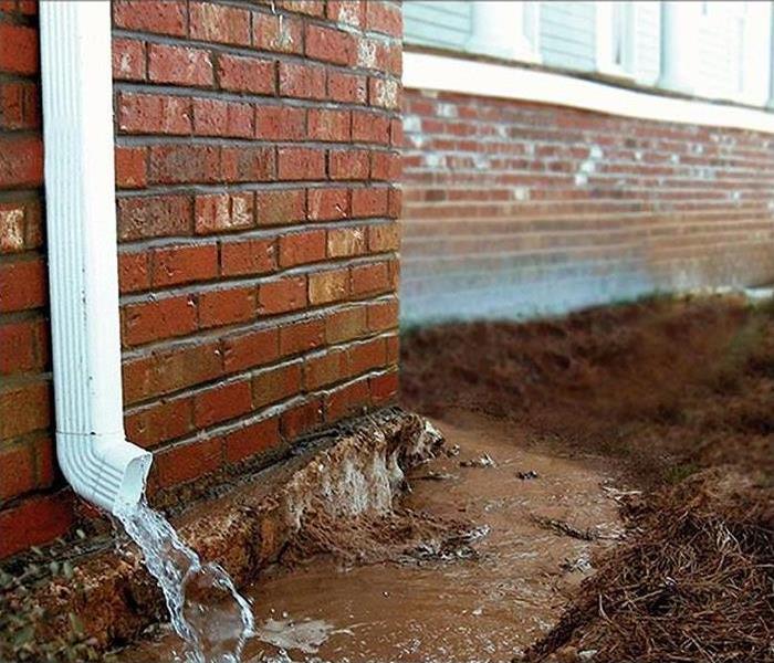 Water flows from a home's gutter to its foundation